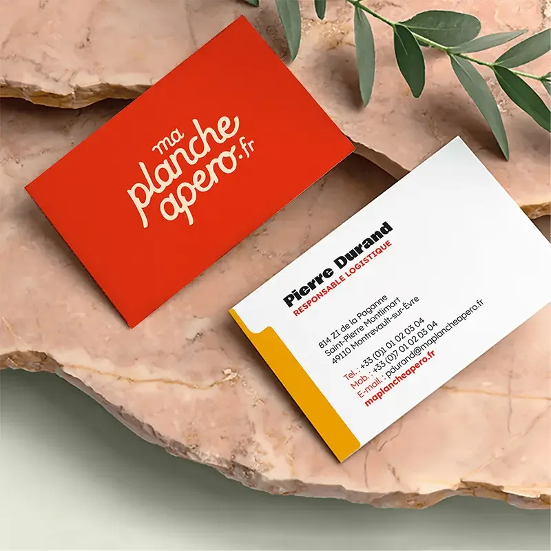 Cartes de visite maplancheapero.fr, recto rouge au logo et verso blanc aux coordonnées, sur une pierre