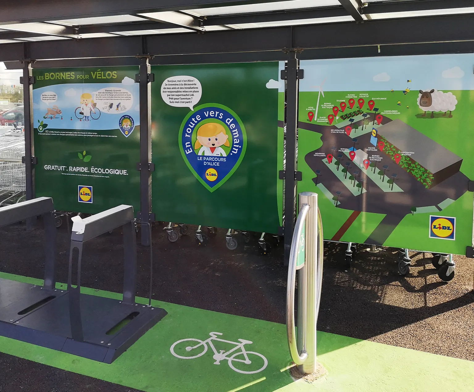 Abri à vélos Lidl habillé des panneaux illustrés En route vers demain, le parcours d'Alice