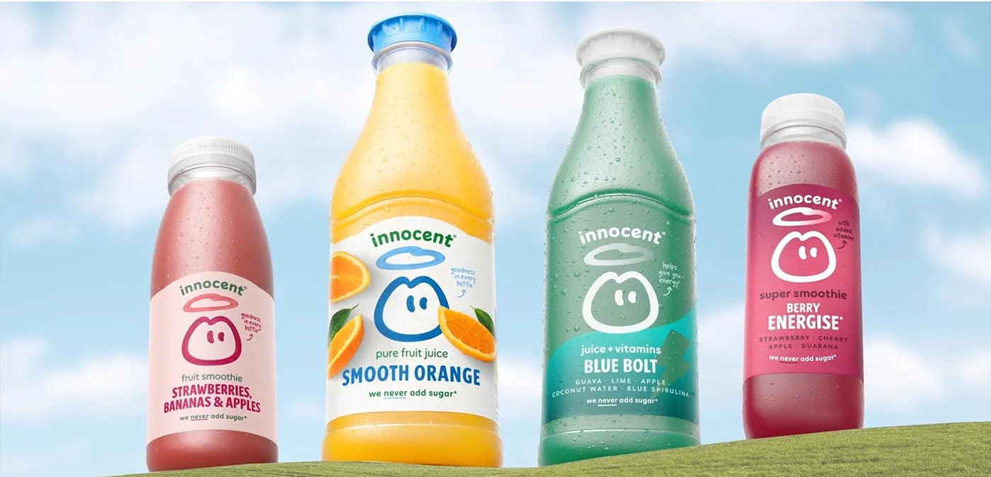 Quatre bouteilles Innocent au nouveau design posées sur une colline devant un ciel nuageux